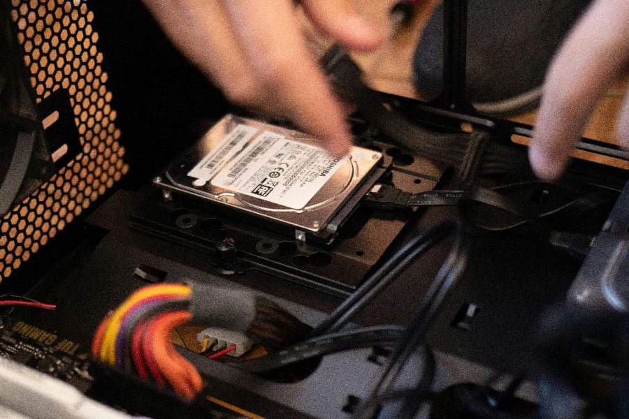 Ein Techniker führt eine Vor-Ort Diagnose & Reparatur an einer internen Festplatte eines Computers durch.