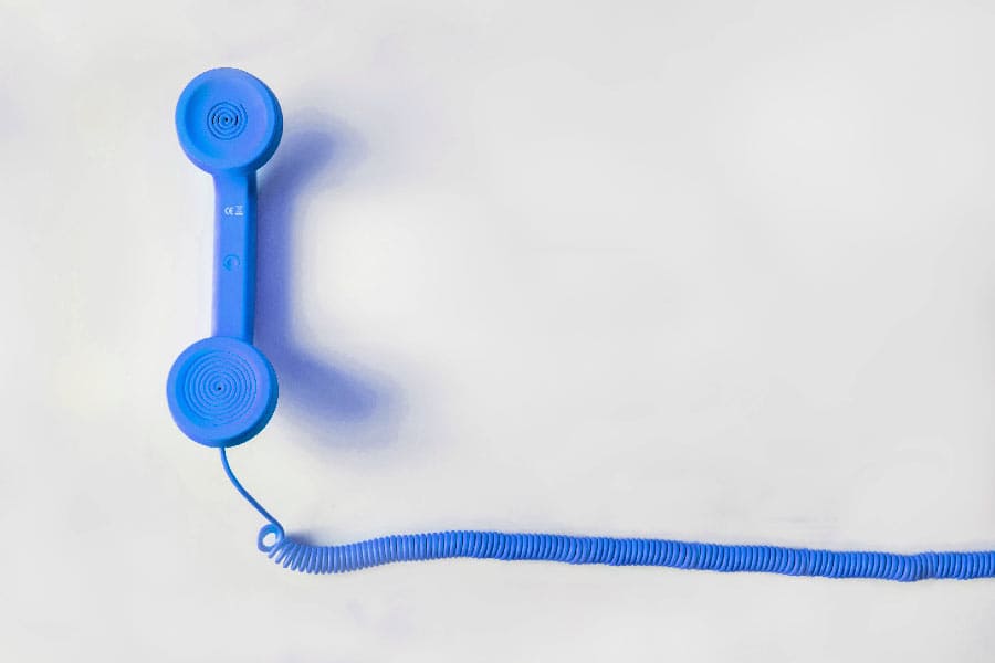 Ein blauer Telefonhörer auf einem weißen Hintergrund, symbolisiert Soforthilfe und 24/7 Support.
