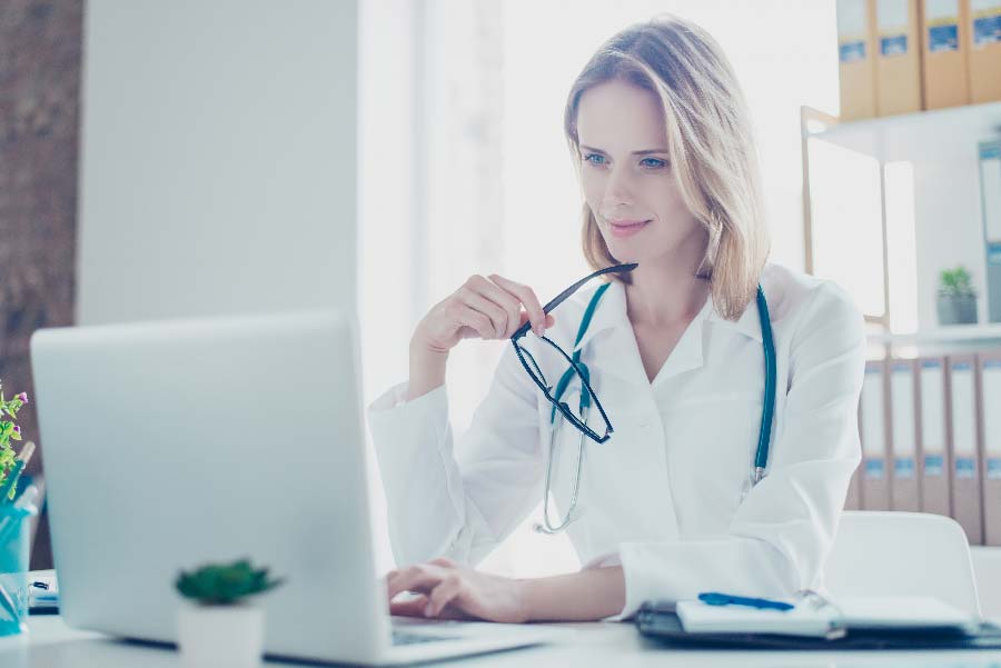 Medizinische Fachangestellte nutzt Laptop, symbolisiert Modernisierung Ihrer Kinderarztpraxis